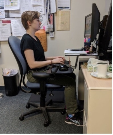 A woman sitting at a desk with exceptionally good posture