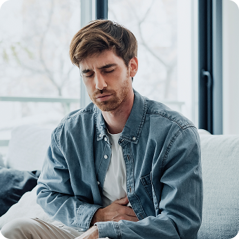 A man holding his midsection and grimacing in pain.